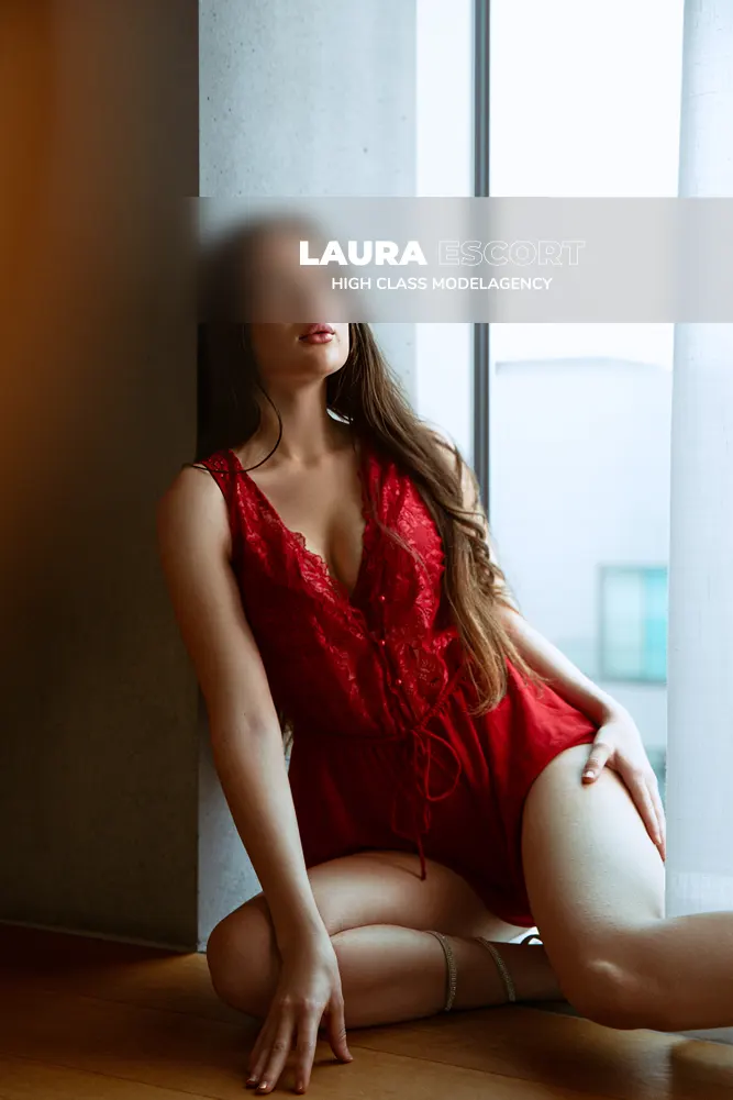 Escort Chloé im Hotelzimmer in rotem Kleid